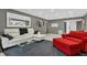 Living room with white sectional sofa, red accent chair, and large mirror at 5128 Marsh Field Ln # 129, Sarasota, FL 34235