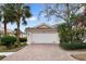 Front view of charming house with brick driveway, attached garage, and lush landscaping at 5839 Helicon Pl, Sarasota, FL 34238
