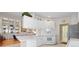 White kitchen with ample cabinetry, stainless steel appliances, and view of living area at 5839 Helicon Pl, Sarasota, FL 34238