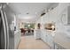 Modern kitchen features white cabinets, stainless steel appliances, and a breakfast bar at 5839 Helicon Pl, Sarasota, FL 34238