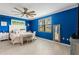 Bright bedroom with blue walls, ceiling fan, and a queen-size bed at 6065 Worsham Ln # 104, Bradenton, FL 34211