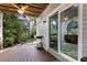Covered back patio with wooden deck, sliding glass door, and lush landscaping at 6250 Holmes Blvd # 71, Holmes Beach, FL 34217