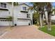 Two-story home with a brick driveway, attached garage, and lush landscaping at 6250 Holmes Blvd # 71, Holmes Beach, FL 34217