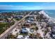 Expansive aerial view showcasing a property with a pool, near the beach, with surrounding homes and lush greenery at 6473 Gulf Of Mexico Dr, Longboat Key, FL 34228