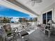 View from the tiled balcony overlooking the beach, with comfortable seating and a ceiling fan at 6473 Gulf Of Mexico Dr, Longboat Key, FL 34228