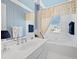 Well-lit bathroom featuring a bathtub, sink, and palm tree wallpaper at 6473 Gulf Of Mexico Dr, Longboat Key, FL 34228