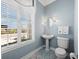 Cozy powder room with pedestal sink, decorative mirror, and mosaic tile flooring at 6473 Gulf Of Mexico Dr, Longboat Key, FL 34228