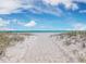 Scenic beach view with white sand, clear ocean, beach umbrellas and a blue sky at 6473 Gulf Of Mexico Dr, Longboat Key, FL 34228
