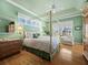 Serene bedroom with a four-poster bed, complemented by soft green walls and ample natural light at 6473 Gulf Of Mexico Dr, Longboat Key, FL 34228