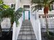 Inviting front entrance featuring a staircase, white railings, a white door, and lush palm trees at 6473 Gulf Of Mexico Dr, Longboat Key, FL 34228
