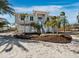 Charming home featuring tropical landscaping, a well-maintained lawn, and a welcoming front entrance at 6473 Gulf Of Mexico Dr, Longboat Key, FL 34228