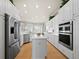 Bright kitchen featuring white cabinetry, stainless steel appliances and hardwood floors at 6473 Gulf Of Mexico Dr, Longboat Key, FL 34228