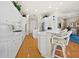 Spacious kitchen with white cabinetry, bar seating, and hardwood floors at 6473 Gulf Of Mexico Dr, Longboat Key, FL 34228