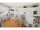 Bright eat-in kitchen featuring white cabinetry, a breakfast bar, and hardwood floors at 6473 Gulf Of Mexico Dr, Longboat Key, FL 34228
