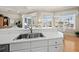 The kitchen sink offers a charming view of the breakfast nook with hardwood floors and natural light at 6473 Gulf Of Mexico Dr, Longboat Key, FL 34228