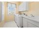 Functional laundry room with modern appliances, a sink, and ample storage at 6473 Gulf Of Mexico Dr, Longboat Key, FL 34228