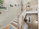 Elegant staircase with wooden railings, multiple framed photos and upstairs landing with a mirror at 6473 Gulf Of Mexico Dr, Longboat Key, FL 34228