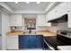 Kitchen with white and blue cabinets, stainless steel appliances at 6884 W Country Club Ln, Sarasota, FL 34243
