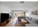Bright living room with a sectional sofa, large TV, and sliding glass doors leading to patio at 6884 W Country Club Ln, Sarasota, FL 34243