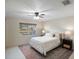 Spacious bedroom with a queen-size bed, large window and ceiling fan at 6884 W Country Club Ln, Sarasota, FL 34243