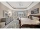 Main bedroom with tray ceiling, large windows, and a dresser at 7019 Vilamoura Pl, Lakewood Ranch, FL 34202