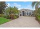 Single-story home with paver driveway, lush landscaping, and palm trees at 7019 Vilamoura Pl, Lakewood Ranch, FL 34202