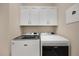 Bright laundry room with side-by-side washer and dryer and upper cabinets at 7019 Vilamoura Pl, Lakewood Ranch, FL 34202