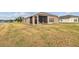 House backyard with screened patio and dry grass at 10605 58Th E St, Parrish, FL 34219