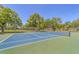 Well-maintained tennis court with surrounding trees at 1188 N Tamiami Trl # 203, Sarasota, FL 34236