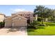Two-story house with a tan exterior, landscaped lawn, and two-car garage at 1269 Western Pine Cir, Sarasota, FL 34240