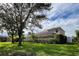 Two-story house with a large backyard, lush landscaping, and a screened lanai at 1269 Western Pine Cir, Sarasota, FL 34240