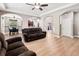 Open concept living room with hardwood floors, brown sofas, and views to the kitchen at 1269 Western Pine Cir, Sarasota, FL 34240