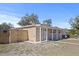 Tan house with a wooden fence and a grassy yard at 1518 Ewing Ave, Clearwater, FL 33756