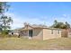 Back of tan house with sliding glass doors and a yard at 1518 Ewing Ave, Clearwater, FL 33756