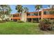 Condo building with grassy backyard and tropical plants at 153 Wild Palm Dr # 153, Bradenton, FL 34210