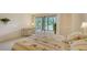 Bright bedroom with floral bedding, sliding glass doors, and a view of the backyard at 153 Wild Palm Dr # 153, Bradenton, FL 34210