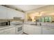 Kitchen with white cabinets, dual sink, and views into the living area at 153 Wild Palm Dr # 153, Bradenton, FL 34210