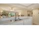 Kitchen with white cabinets, dishwasher, and view to living room at 153 Wild Palm Dr # 153, Bradenton, FL 34210