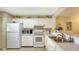 Well-equipped kitchen featuring white cabinets, microwave, and electric range at 153 Wild Palm Dr # 153, Bradenton, FL 34210
