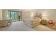 Main bedroom with floral bedding, wicker furniture, and access to a patio at 153 Wild Palm Dr # 153, Bradenton, FL 34210