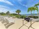 Relaxing patio overlooking the water with lounge chairs and a grill at 1618 Stickney Point Rd # 1618-202, Sarasota, FL 34231