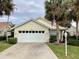 House exterior featuring a two-car garage and lush landscaping at 1803 Ashley Dr, Venice, FL 34292