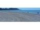 Expansive beach with tire tracks and people walking at 240 Sands Point Rd # 4201, Longboat Key, FL 34228