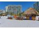 Beach access with thatch roof cabana, kayaks, and condo building at 240 Sands Point Rd # 4201, Longboat Key, FL 34228