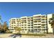 Beige building with balconies, palm trees, and beach at 240 Sands Point Rd # 4201, Longboat Key, FL 34228