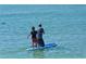 Father and son enjoy paddleboarding in calm waters at 240 Sands Point Rd # 4201, Longboat Key, FL 34228