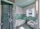 Bathroom with teal tile, glass block, and bathtub at 2425 Riverview Blvd, Bradenton, FL 34205