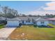 White single-story home with a two-car garage and well-maintained lawn at 2425 Riverview Blvd, Bradenton, FL 34205