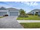 Two-story house with gray siding, paver driveway, and palm trees at 2616 Sapphire Blue Ln, Bradenton, FL 34211