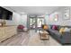 Bright living room with gray sectional and wood-look floors at 2744 Hidden Lake Blvd # A, Sarasota, FL 34237